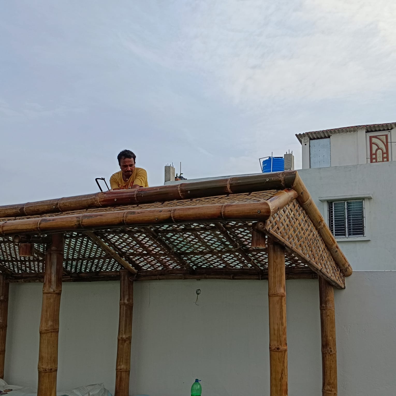 Karigar on pergola roof assembling bamboo lattice