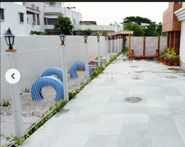 Play corridor: stone paving, lattice screens, tyre obstacles