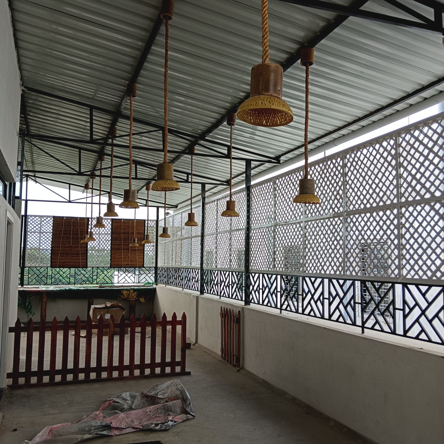 Cafe with pendant lamps and cane blinds installed, pre-furniture